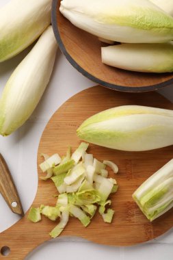 Beyaz fayanslı masa üzerinde taze çiğ Belçika hindibaları (chicory), düz konum