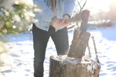 Kışın açık havada baltayla odun kesen adam, yakın plan.