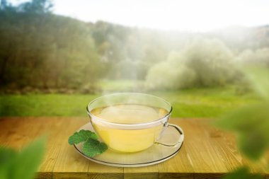 Cam bardakta Aromatik yeşil çay ve açık havada tahta masada nane.