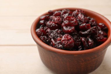 Hafif ahşap masada, tabakta kurutulmuş yaban mersini, yakın plan.