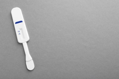 Açık gri arka planda tek kullanımlık ekspres test, üst görünüm. Metin için boşluk