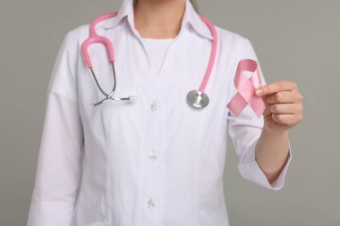 Gri arka planda pembe kurdeleli Mammolog, yakın plan. Göğüs kanseri farkındalığı