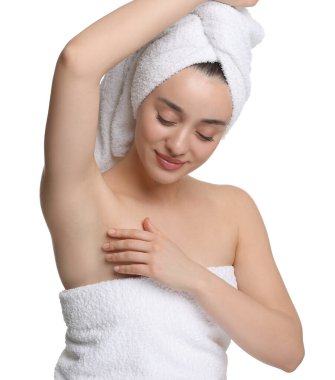 Güzel bir kadın, beyaz arka planda pürüzsüz, temiz bir ciltle koltukaltı gösteriyor.