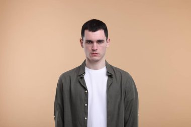 Bej arka planda üzgün bir adamın portresi