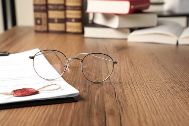 Evraklar ve gözlükler ahşap masada, yazı için yeri olan yakın plan. Noter sözleşmesi