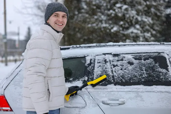 Człowiek Czyszczący Śnieg Samochodu Szczotką Zewnątrz — Zdjęcie stockowe