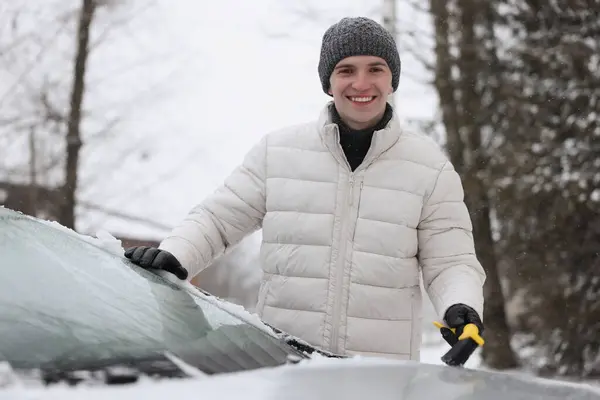 Człowiek Czyszczący Śnieg Maski Samochodu Zewnątrz — Zdjęcie stockowe