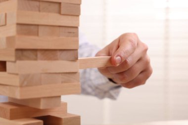 Jenga oynuyorum. İçerideki kuleden ahşap bloğu kaldıran adam, yakın plan.