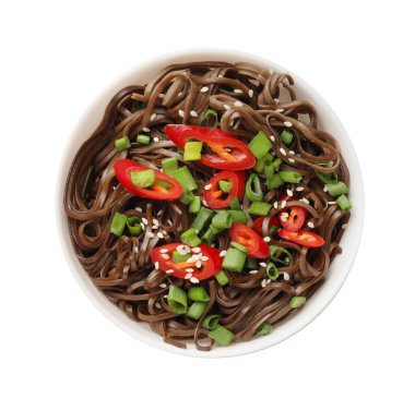 Lezzetli karabuğday eriştesi (soba) biber biberli ve soğanlı, beyaz tencereye izole edilmiş, üst manzara.