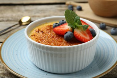 Böğürtlenli ve nane şekerli nefis creme brulee ahşap masada, yakın plan