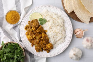Lezzetli köri soslu tavuk ve malzemeler beyaz fayanslı masada, düz yerde.