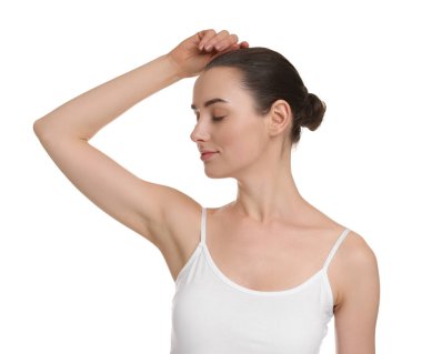 Güzel bir kadın, beyaz arka planda pürüzsüz, temiz bir ciltle koltukaltı gösteriyor.