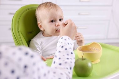 Anne, küçük bebeğini sağlıklı yiyeceklerle besliyor.