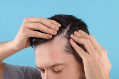 Koyu mavi arka planda kepekli bir adam, yakın plan.