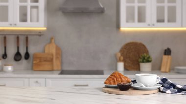 Kahvaltı mutfakta servis edilir. Taze kruvasan, kahve ve reçel. Metin için boşluk