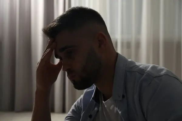 Sad young man near on blurred background