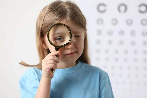 Mała Dziewczynka Szkłem Powiększającym Wykresie Testu Wzroku — Zdjęcie stockowe