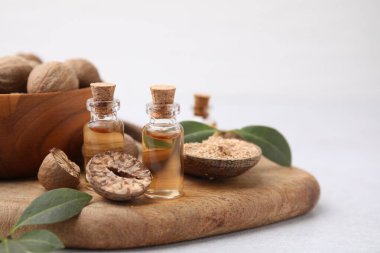 Nutmeg esaslı yağ, fındık ve yapraklar ışık masasında. Metin için boşluk