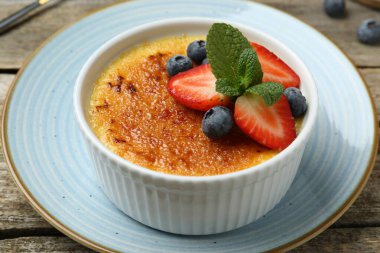 Böğürtlenli ve nane şekerli nefis creme brulee ahşap masada, yakın plan