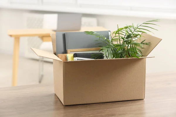 Unemployment problem. Box with worker\'s personal belongings on table in office