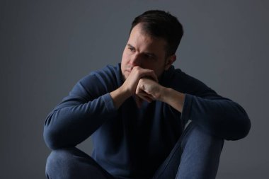 Koyu gri arka planda üzgün bir adamın portresi