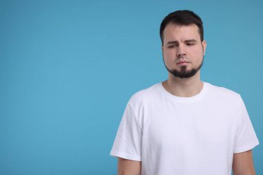 Açık mavi arkaplanda üzgün bir adamın portresi, metin için boşluk