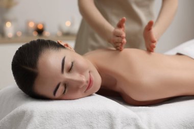 Spa salonundaki kanepede sırt masajı yaptıran kadın.