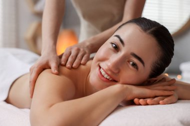 Spa salonundaki kanepede sırt masajı yaptıran kadın.