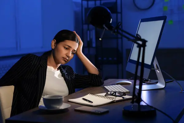 Tired businesswoman working at night in office