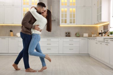 Mutfakta öpüşen sevimli genç bir çift. Metin için boşluk