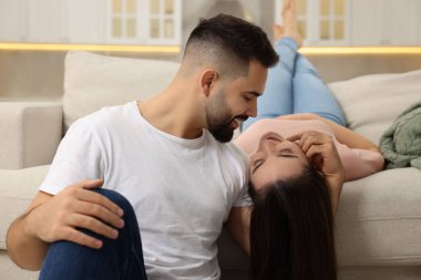 Sevecen genç bir çift kanepede birlikte vakit geçiriyorlar.