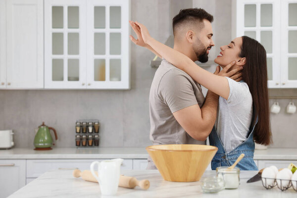 Affectionate young couple spending time together in kitchen. Space for text