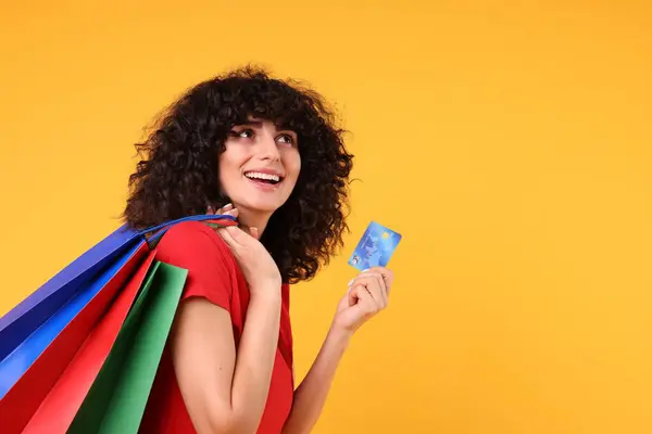 Sarı Arka Planda Alışveriş Torbaları Kredi Kartı Olan Mutlu Genç — Stok fotoğraf