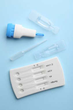 Tek kullanımlık çoklu enfeksiyon ekspres test kiti açık mavi arkaplan, düz yatar