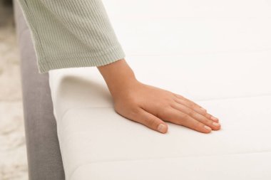 Beyaz yumuşak şilteye dokunan kadın, yakın plan.