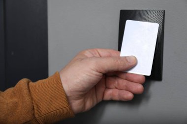 Manyetik kapı kilidini anahtar kartıyla açan adam, yakın plan. Ev güvenliği