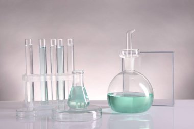 Laboratuvar analizi. Aydınlık arkaplan karşısında farklı cam eşyalar