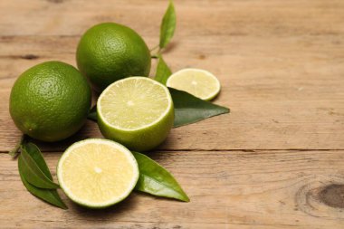 Tahta masada taze limon ve yapraklar. Metin için boşluk