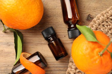 Düz kompozisyon ve ahşap masa üzerinde mandalina yağı vardı.