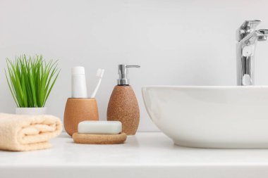 Beyaz masada farklı banyo aksesuarları ve ürünleri var.