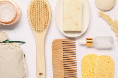 Banyo aksesuarları. Farklı kişisel bakım ürünleri ve beyaz arka planda kuru dikenler.