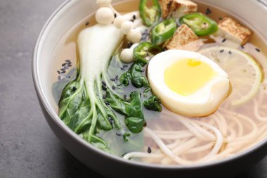 Gri masada bir kase vejetaryen ramen, yakın plan.