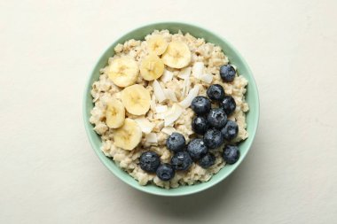 Muzlu yulaf ezmesi, yaban mersini, hindistan cevizi gevreği ve bal bej masadaki kasede servis edilir.