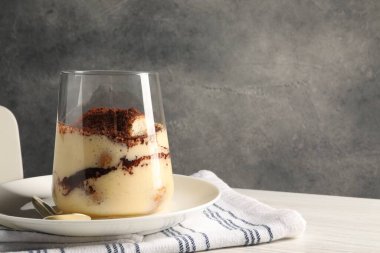 Beyaz ahşap masada cam içinde nefis tiramisu, yakın plan. Metin için boşluk