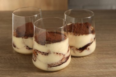 Ahşap masada gözlüklü nefis tiramisu, yakın plan.
