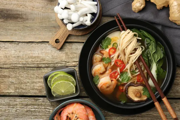 Lezzetli ramen ve ahşap masa malzemeleri ile düz kompozisyon, metin için yer. Erişte çorbası.
