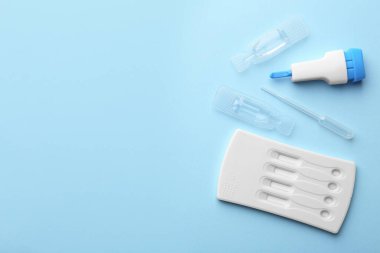 Açık mavi arka planda tek kullanımlık test kiti, düz konum. Metin için boşluk