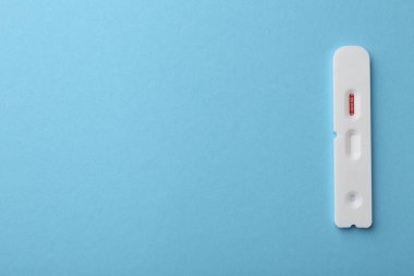 Tek kullanımlık Covid-19 ekspres test açık mavi arka plan, üst görünüm. Metin için boşluk