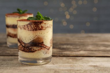 Lezzetli tiramisu ve naneli bardaklar ahşap masada, yakın plan. Metin için boşluk
