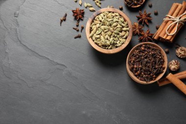 Koyu gri desenli masada farklı baharatlar var. Metin için boşluk